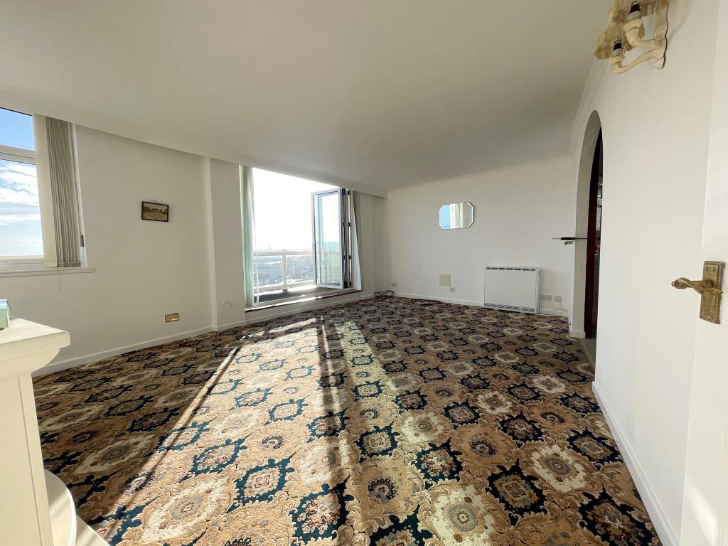 Lot: 131 - PENTHOUSE FLAT WITH STUNNING VIEWS OF SEAFRONT AND SURROUNDING COUNTRYSIDE - Living room with doors to balcony